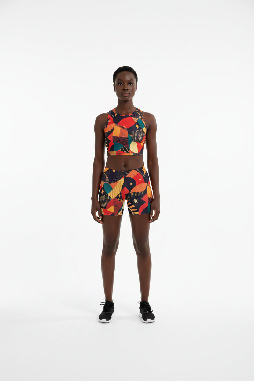 Person wearing a colorful patterned asake_oge_igba_african_print_juneteenth_festival_wearprint-shorts outfit on a white background