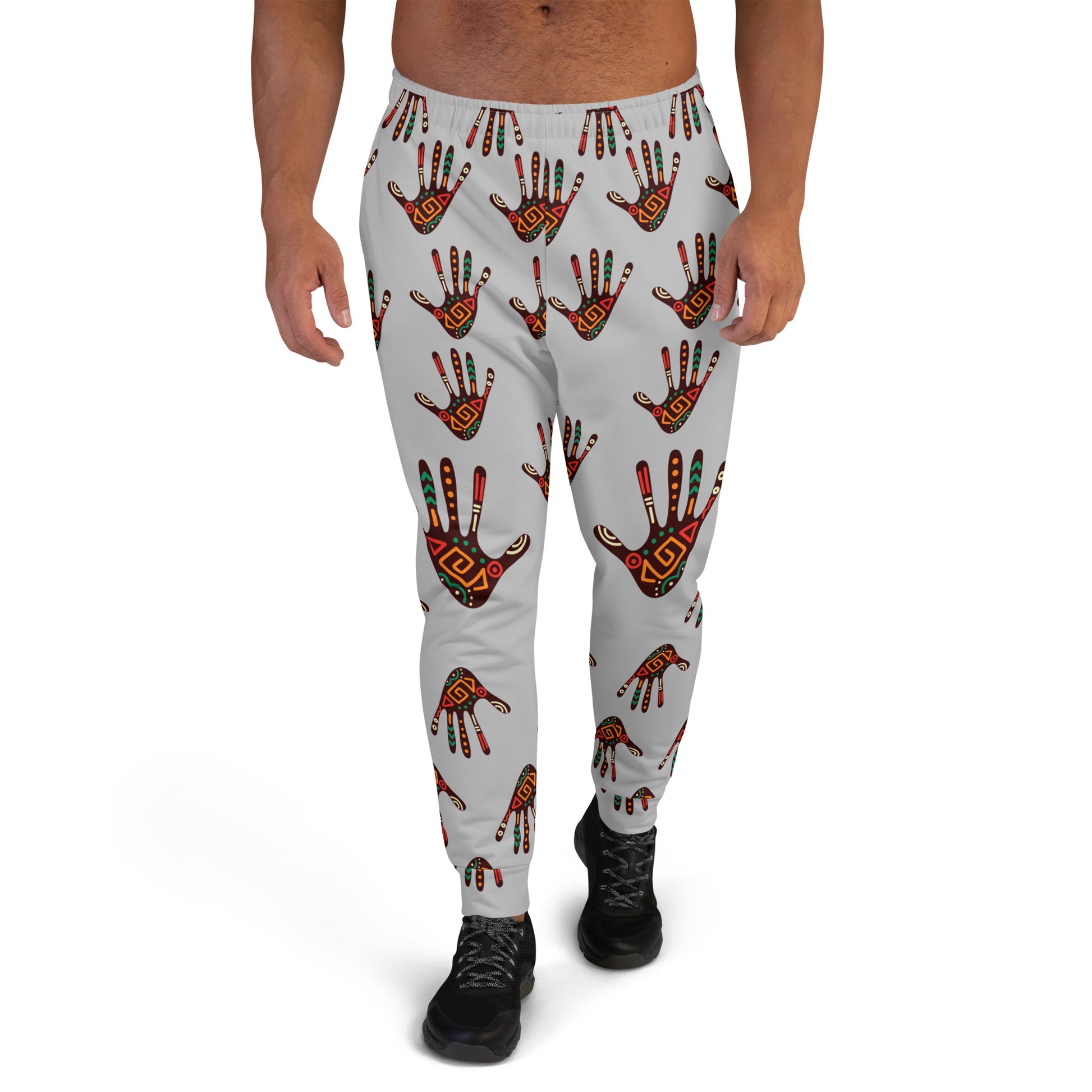 A man wearing grey joggers with a vibrant tribal palm print design.