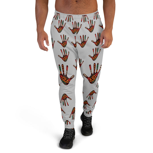 A man wearing grey joggers with a vibrant tribal palm print design.