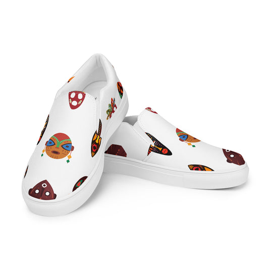 A pair of men's slip-on canvas shoes with a white base and a design featuring colorful tribal mask patterns.