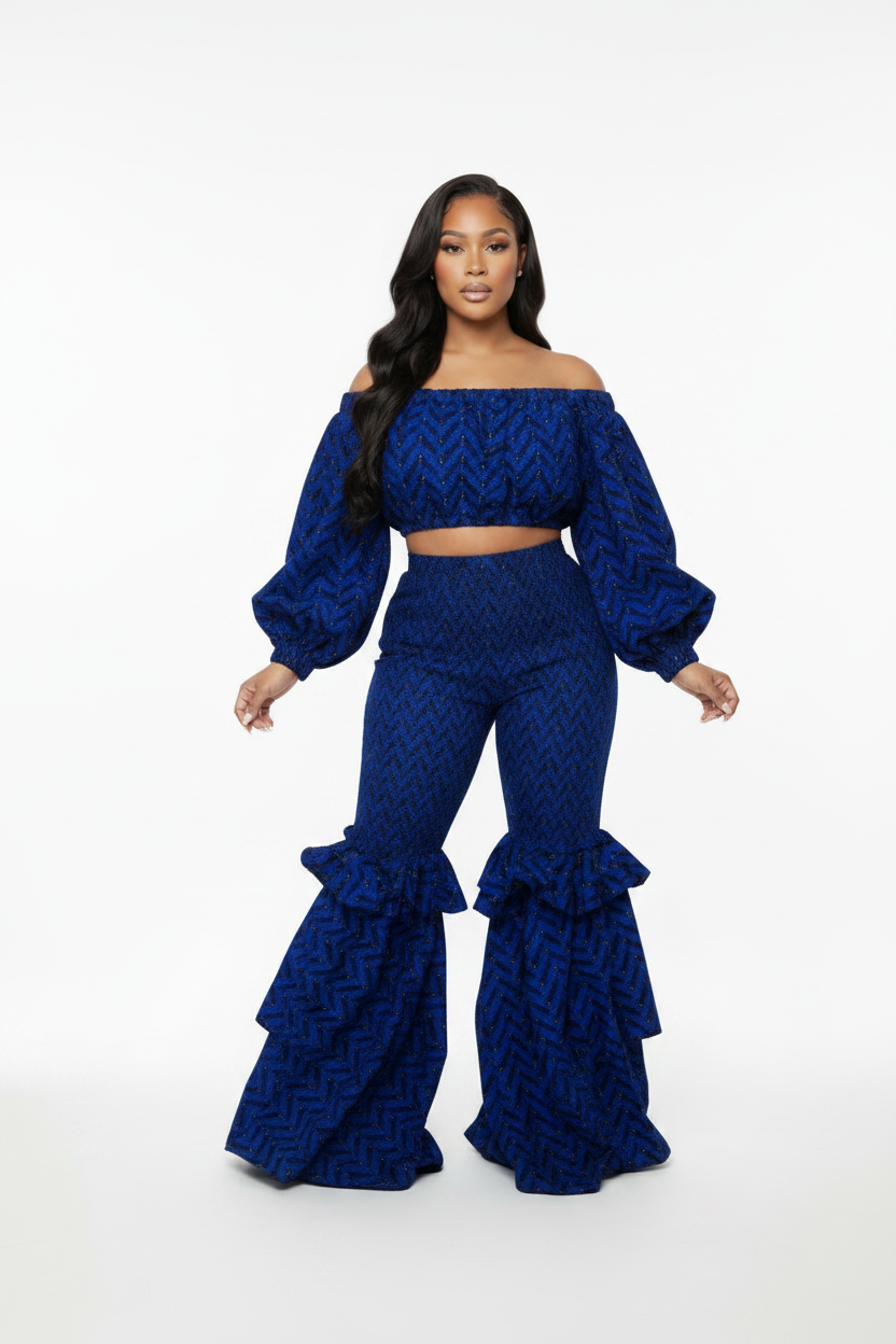 Woman wearing a blue patterned outfit with ruffled pants on a white background