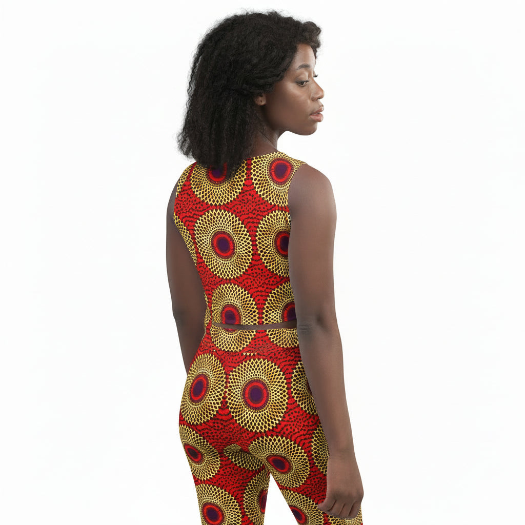 A woman shown from the back wearing a sleeveless one-piece jumpsuit with a bold red, gold, and navy circular pattern, set against a plain white background.