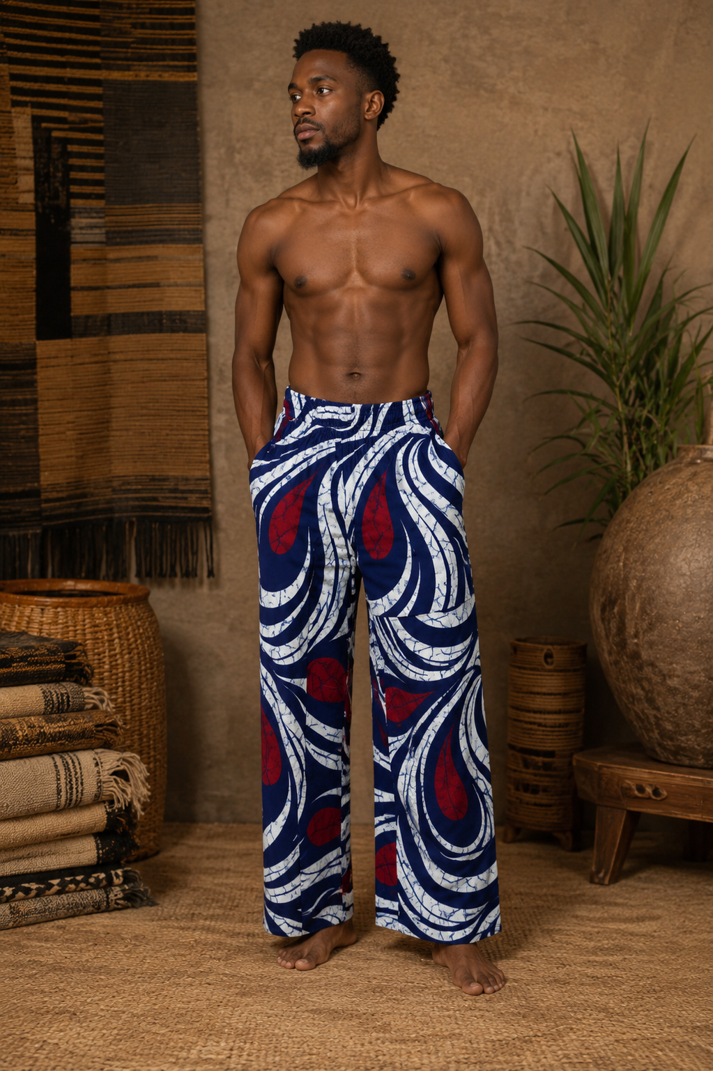 Man wearing blue and red patterned pants standing in a rustic interior setting.