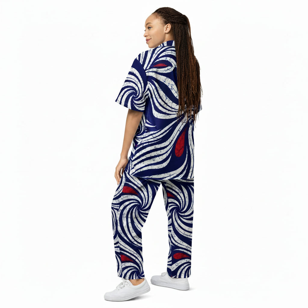  Adire-inspired navy blue and white swirl print unisex button shirt, oversized fit, worn by a dark-skinned woman with long braids, back view
