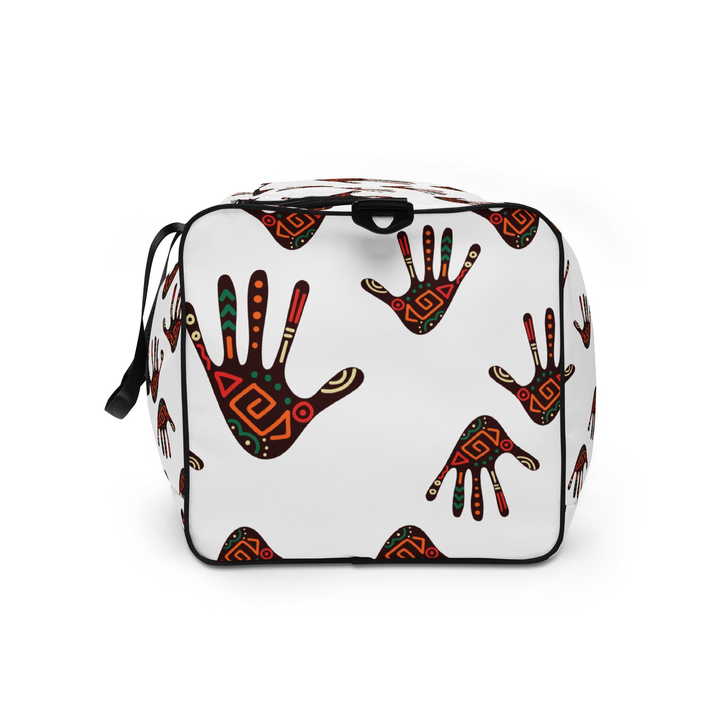 Upclose view showing the left side of a white duffle bag, covered with a colorful tribal palm print design, featuring multiple pockets, a black adjustable padded shoulder strap, and dual padded handles.