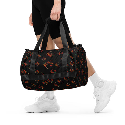  A woman holding the Duro Midnight Tribal Palm Print Overnight Gym Bag by hand, with its dual shorter straps.