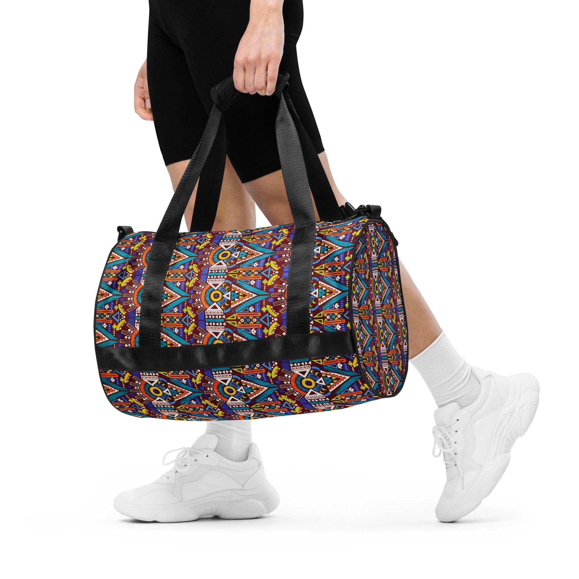 A woman holding Tozi Aztec Print Overnight Gym Bag by hand, with its dual shorter straps.