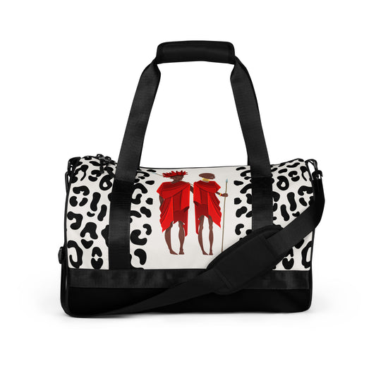 Front view of the Agojie Animal Print Gym Overnight Bag showcasing the white and black animal prints and custom Sahara warriors clothed in red wrappers.