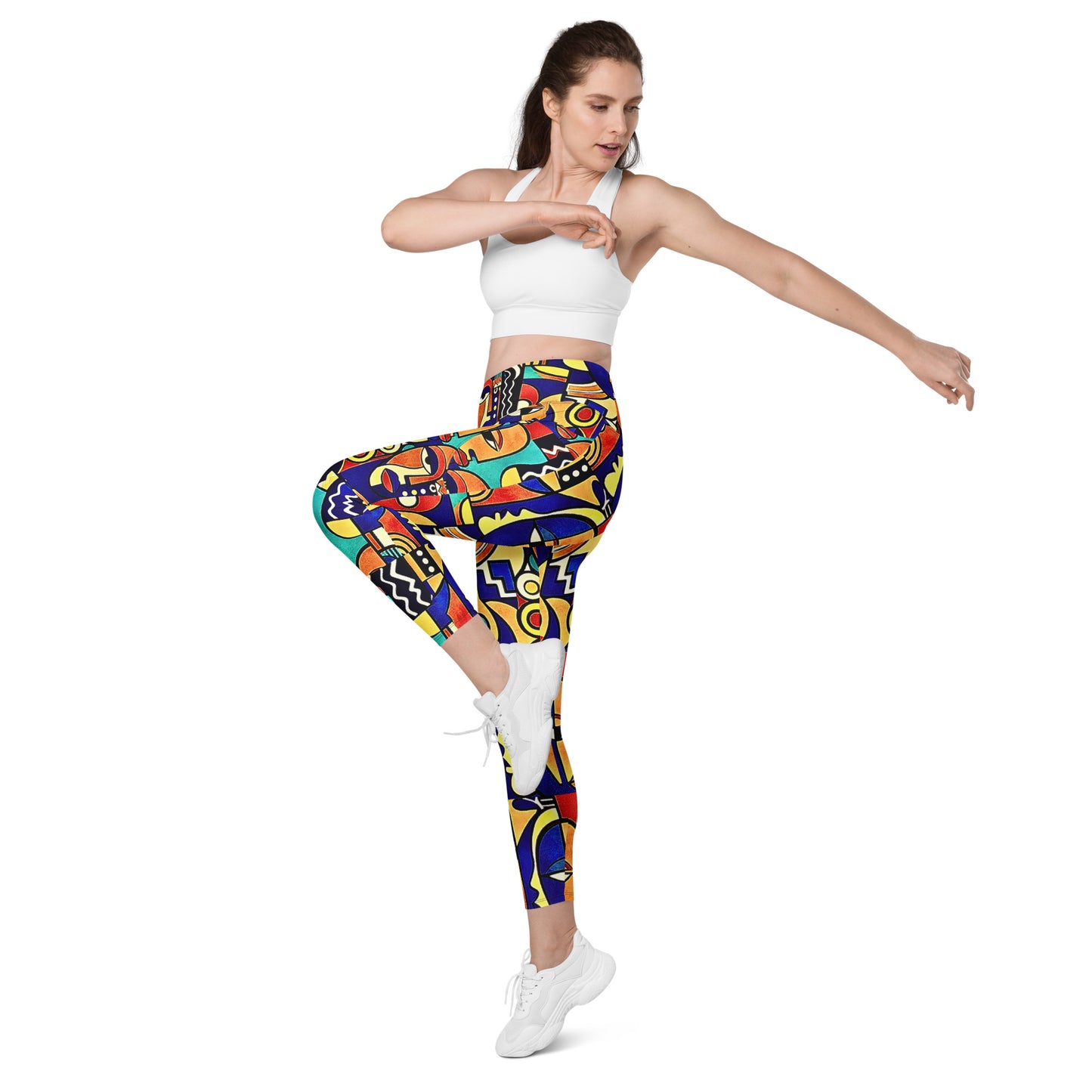 Woman wearing colorful patterned Asake oge leggings and a white sports bra on a white background