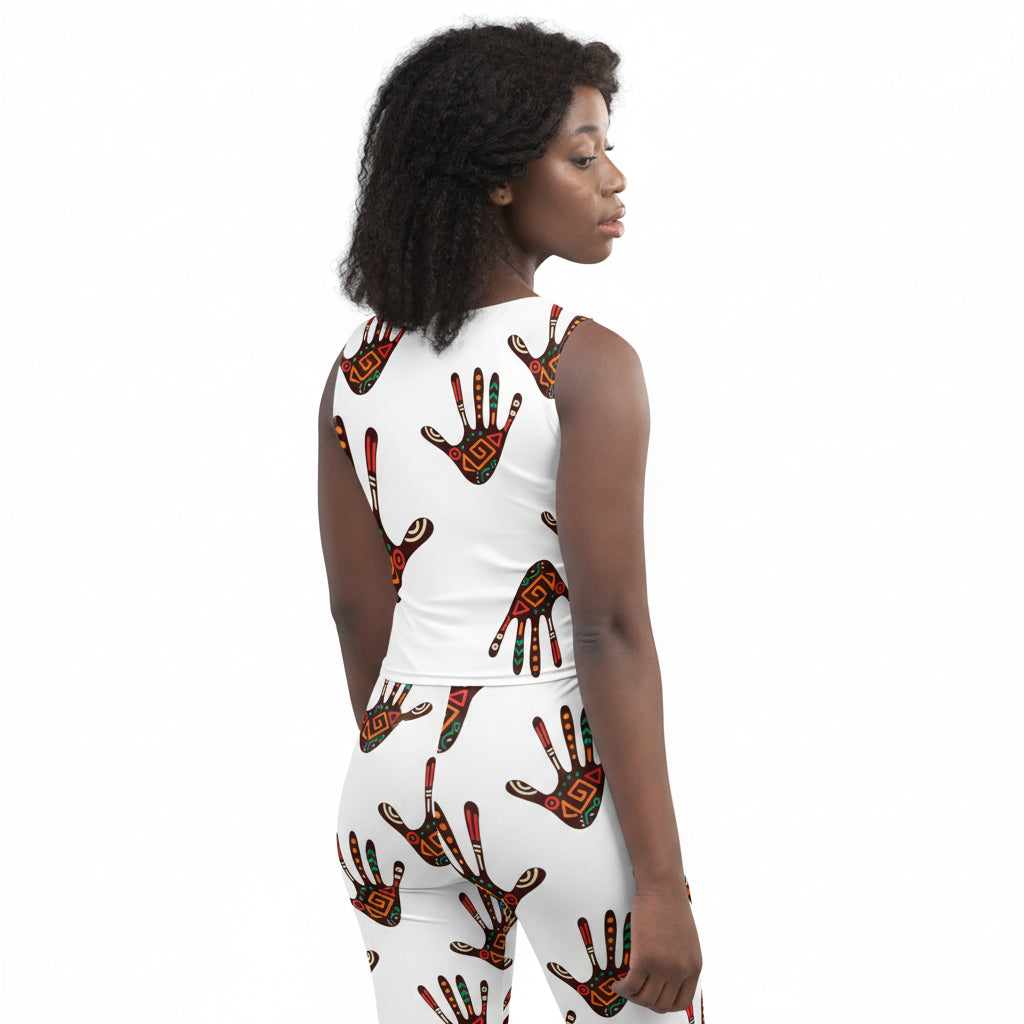 A woman shown from the back wearing a white sleeveless crop top and matching leggings set, both printed with a repeating red, black, and green hand design, against a plain white background.