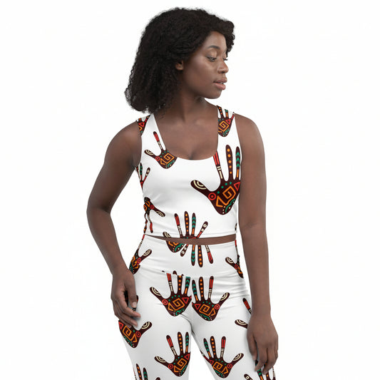 A woman modeling a matching white two-piece set with a bold African handprint pattern, shown against a plain white background.