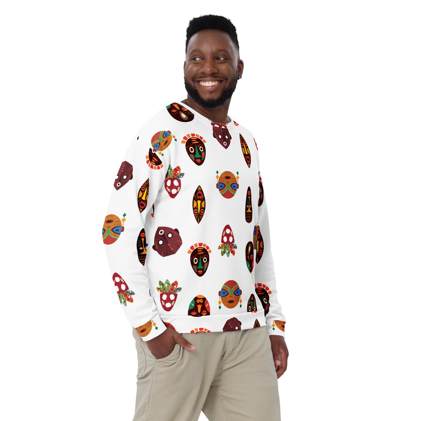 A man wearing a long-sleeve unisex sweatshirt with a colorful tribal mask pattern.