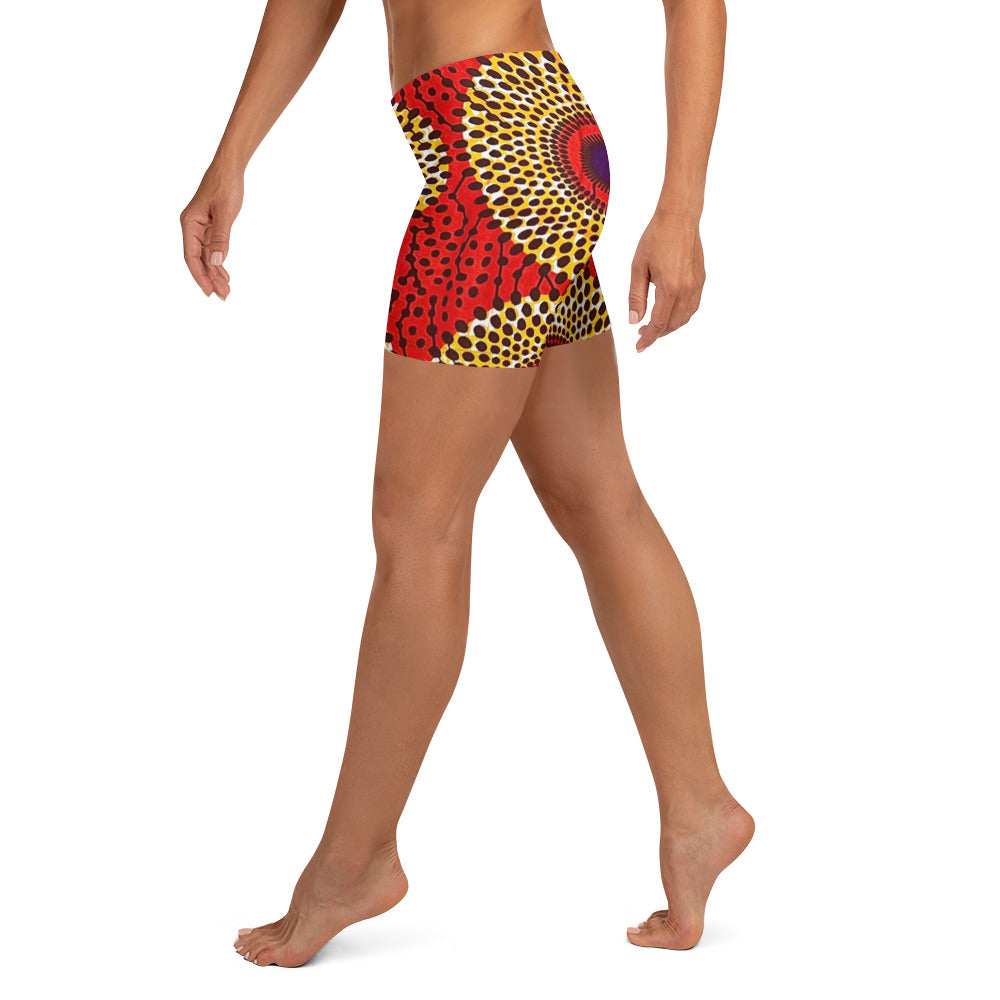 Side view of barefoot woman wearing vibrant colored, geometric-pattern Rekiana African print athleisure sport shorts