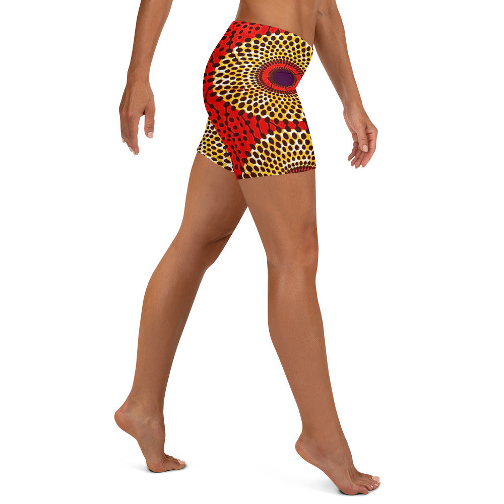 Side view of barefoot woman wearing vibrant colored, geometric-pattern Rekiana African print athleisure sport shorts