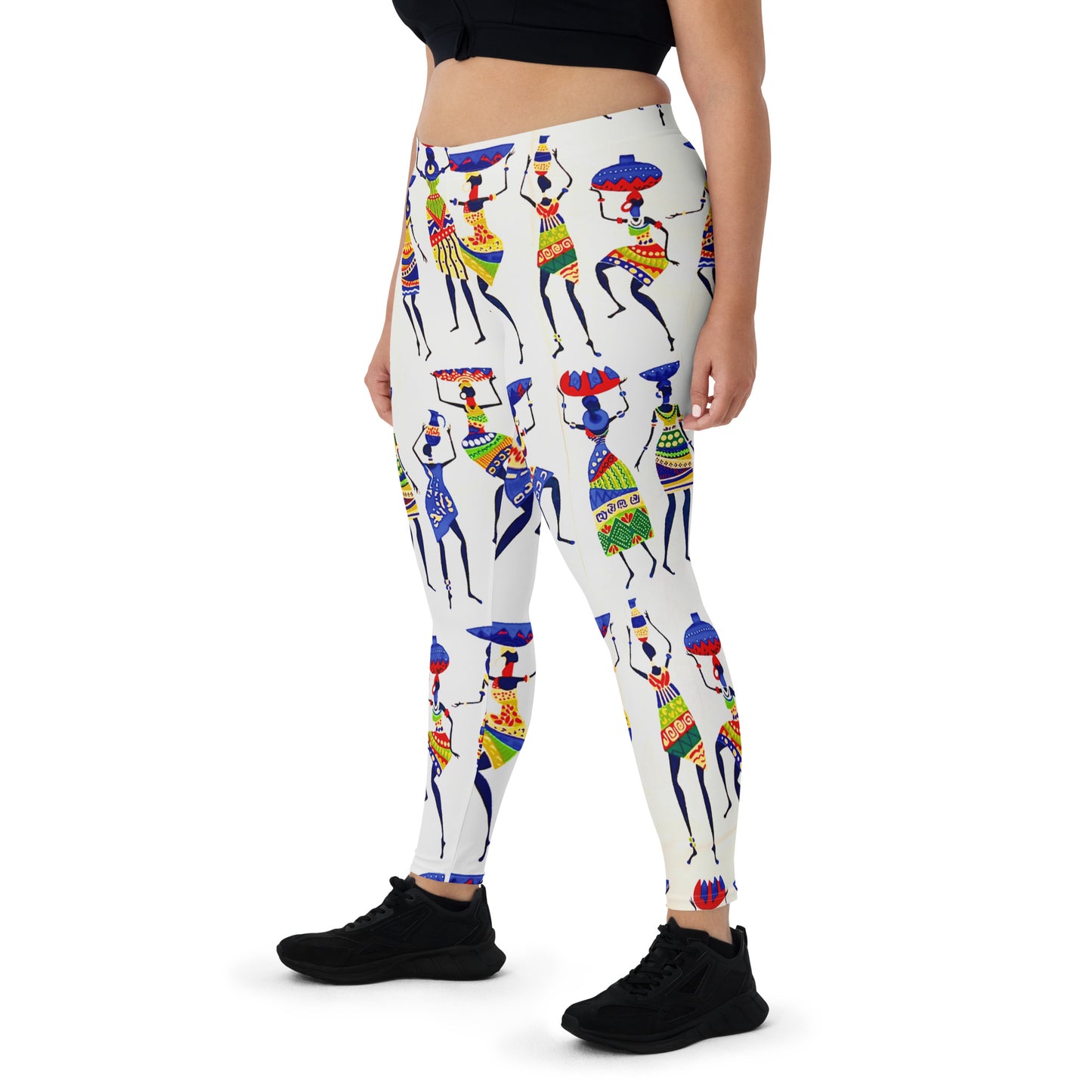Frontal side view of thick-bodied woman wearing sneakers and Yeye workout yoga leggings; showcasing a close up view of the colorful depiction of African women dancing and carrying calabashes and jars