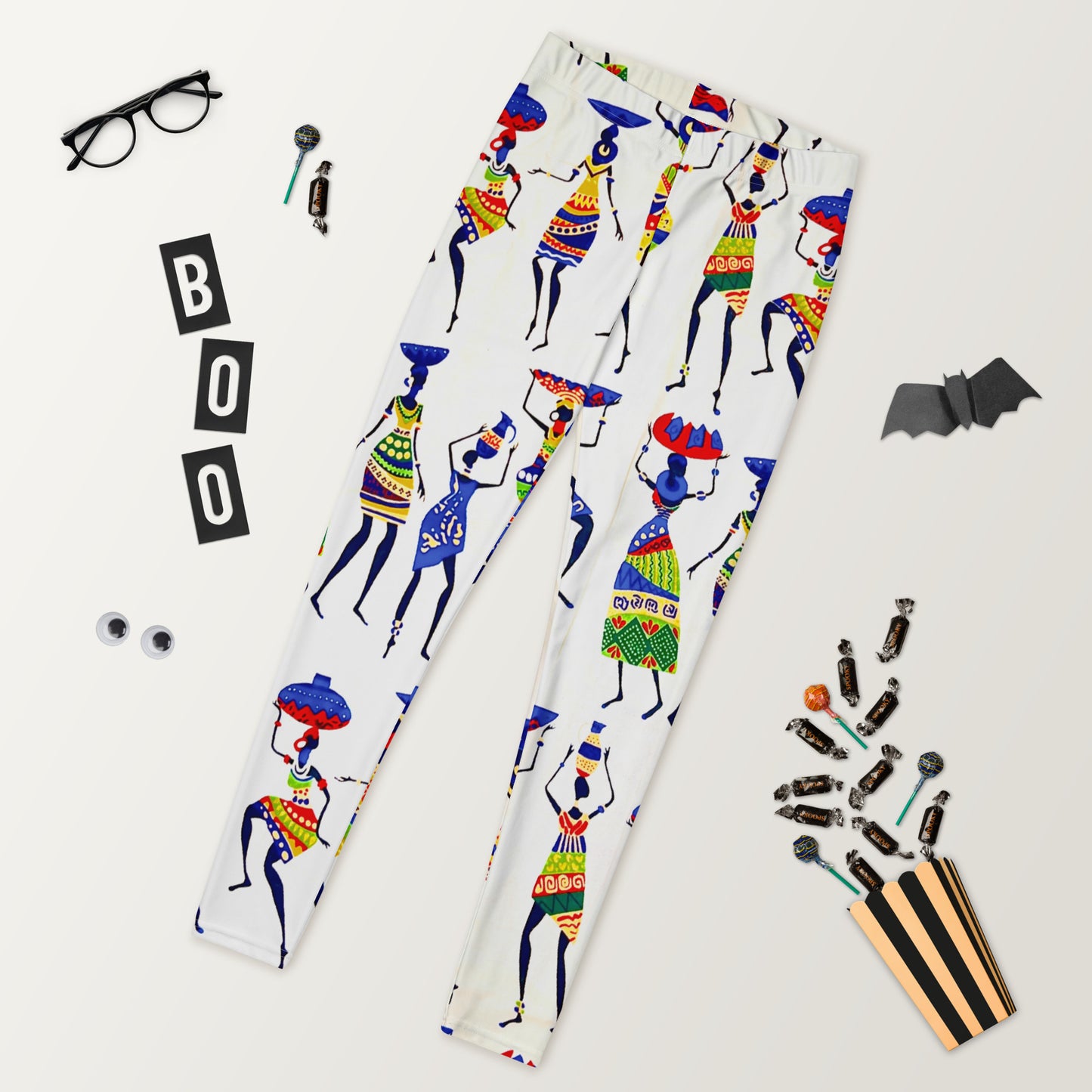 Halloween vibe view of Yeye Workout Yoga Athleisure Leggings laid out; flanked by a cut-out bat, glasses, and candy.