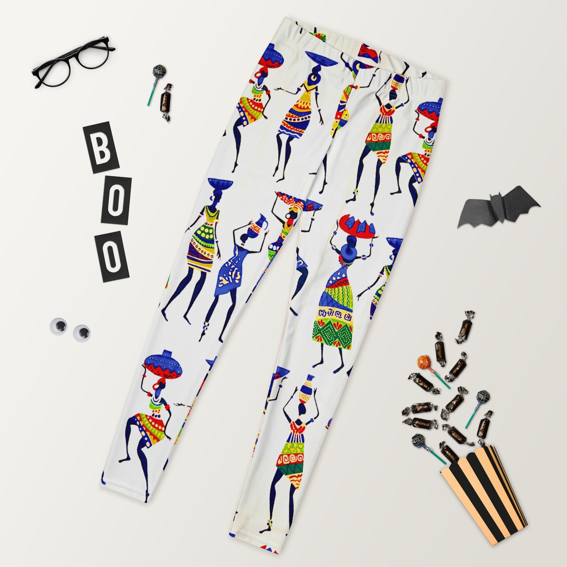 Halloween vibe view of Yeye Workout Yoga Athleisure Leggings laid out; flanked by a cut-out bat, glasses, and candy.
