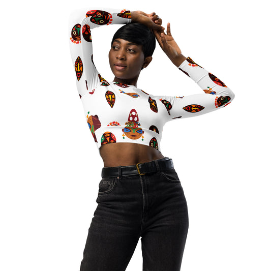 A woman wearing a long sleeve crop top with a colorful tribal mask pattern.