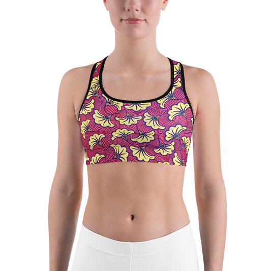 A woman wearing a sports workout bra top with a colorful floral pattern.
